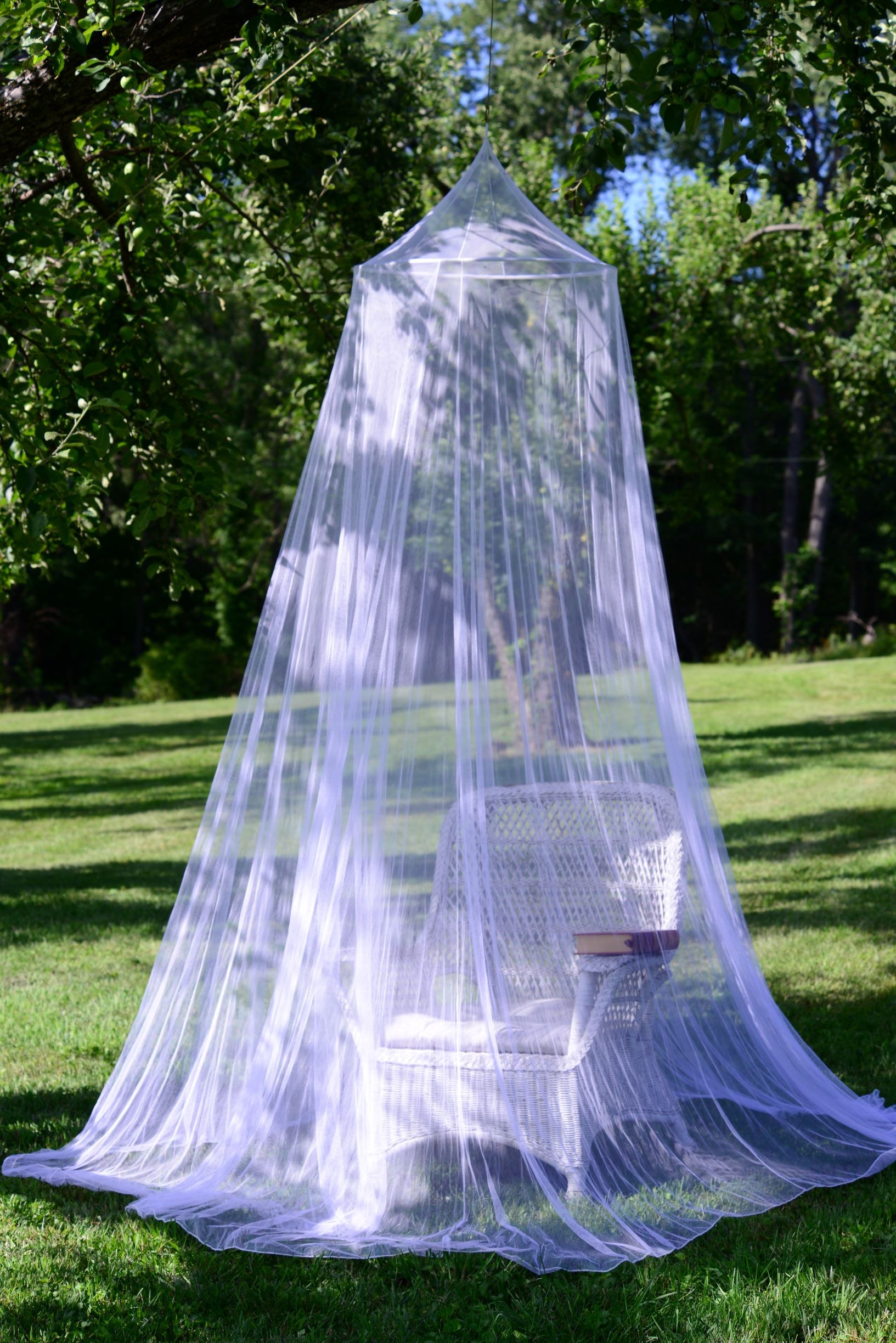 Circular expedition mosquito net net hanging outside over chair